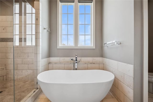 16121 Paradise St, Overland Park, KS 66221 - bathroom featuring a freestanding tub, a tile shower, and tile walls