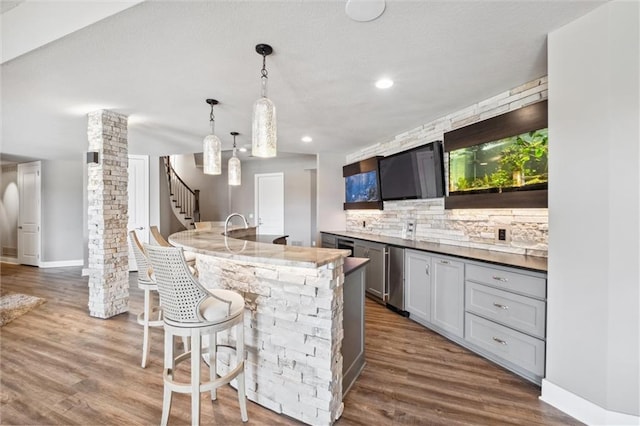 16121 Paradise St, Overland Park, KS 66221 - kitchen with dark wood-style flooring, backsplash, a kitchen bar, hanging light fixtures, and recessed lighting