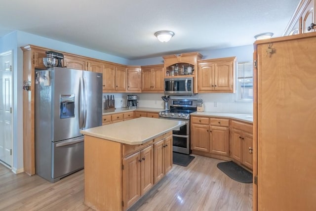 kitchen featuring light wood-style floors, light countertops, appliances with stainless steel finishes, and a center island