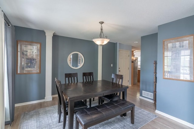 dining room with visible vents, baseboards, and wood finished floors