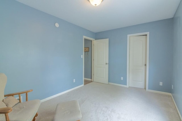 unfurnished room with light colored carpet and baseboards