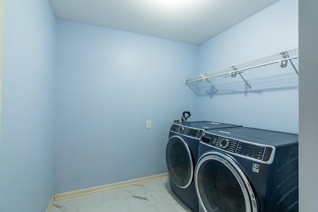 laundry room with baseboards, laundry area, marble finish floor, and washer and clothes dryer