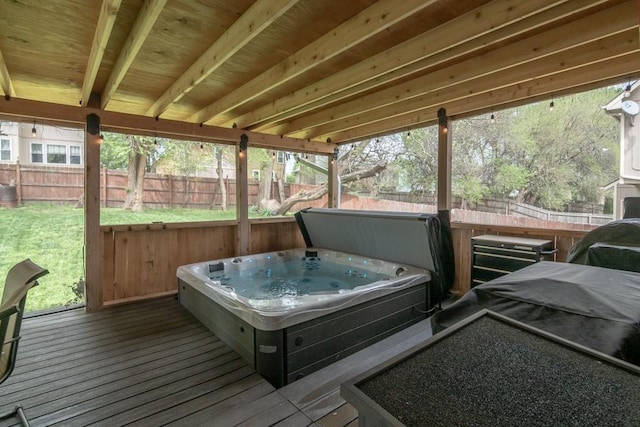 deck with a lawn, hot tub deck surround, and a fenced backyard