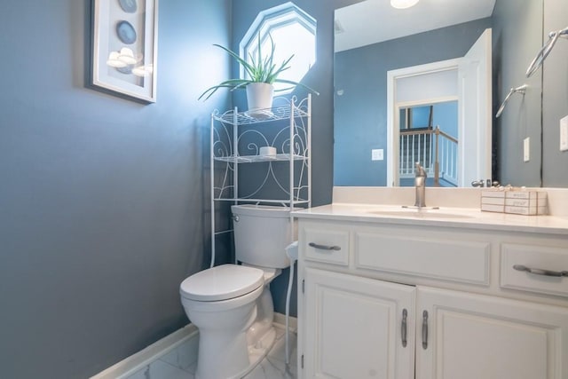 bathroom featuring toilet, baseboards, marble finish floor, and vanity