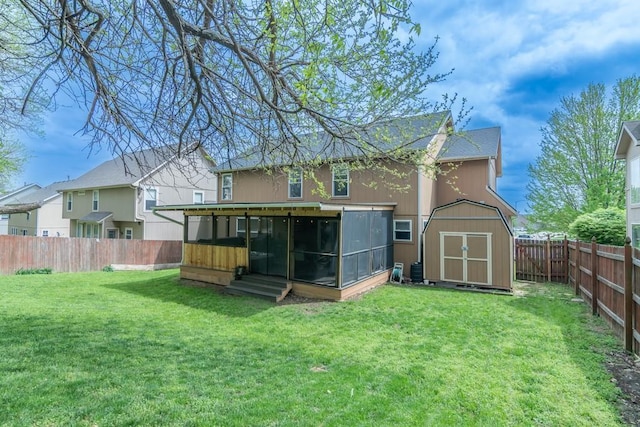 rear view of property with a yard, a storage shed, a fenced backyard, and a sunroom
