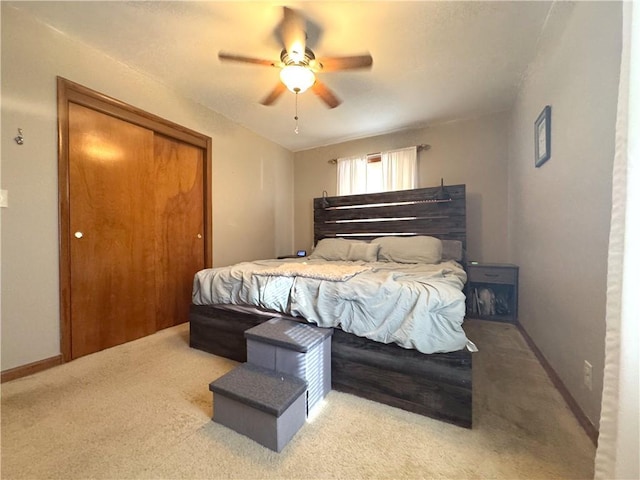 bedroom with a closet, baseboards, carpet, and a ceiling fan