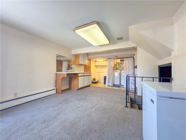 interior space featuring washing machine and dryer, visible vents, baseboard heating, and light carpet