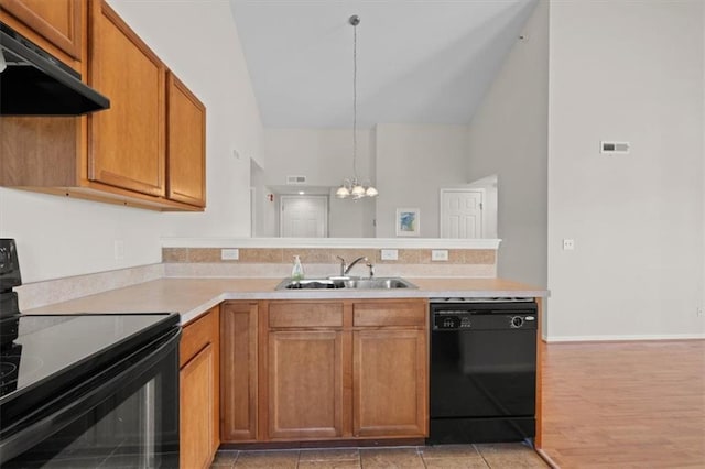 5501 NE 80th Ter Unit 3A, Kansas City, MO 64119 - kitchen with a sink, a chandelier, a peninsula, under cabinet range hood, and black appliances