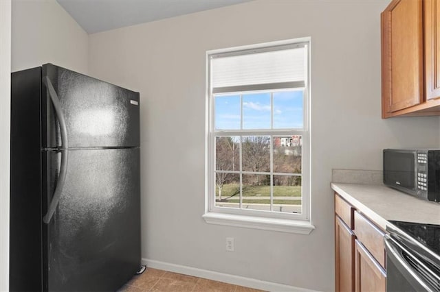 5501 NE 80th Ter Unit 3A, Kansas City, MO 64119 - kitchen featuring light countertops, baseboards, plenty of natural light, and black appliances