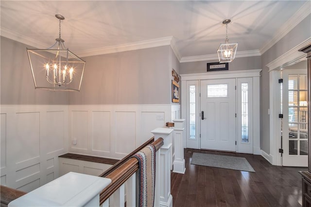 entrance foyer featuring a chandelier, dark wood finished floors, and crown molding