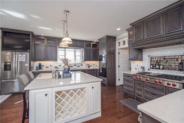 kitchen featuring stainless steel appliances, dark brown cabinetry, and light countertops