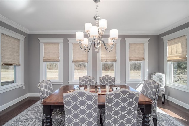 dining area with an inviting chandelier, crown molding, wood finished floors, and baseboards