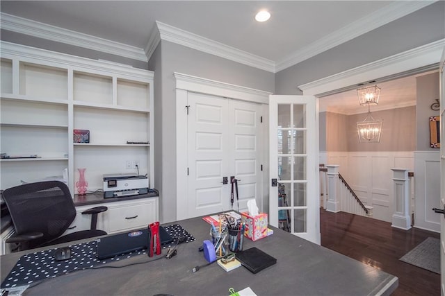 office space featuring an inviting chandelier, crown molding, wood finished floors, and a wainscoted wall