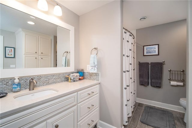 bathroom with a shower with curtain, toilet, tasteful backsplash, baseboards, and vanity