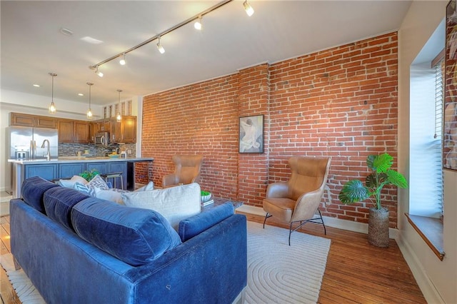 living area featuring light wood-style floors and brick wall