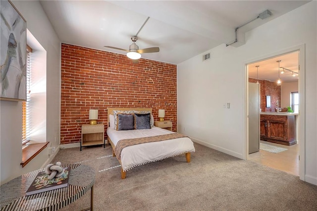 bedroom with carpet flooring, visible vents, stainless steel fridge, and brick wall