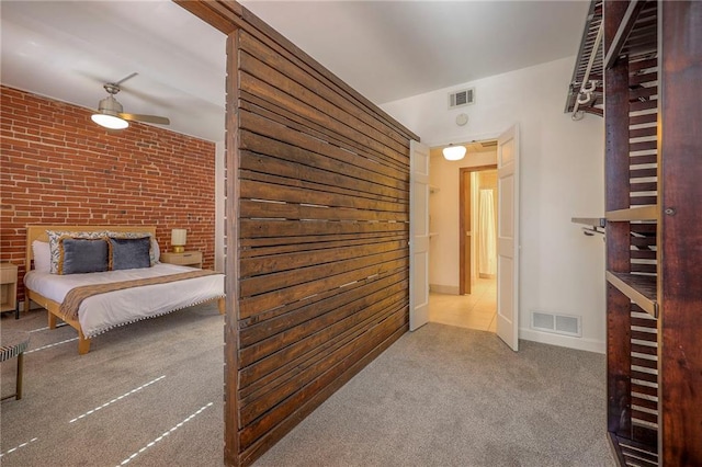 unfurnished bedroom with visible vents, carpet floors, and brick wall