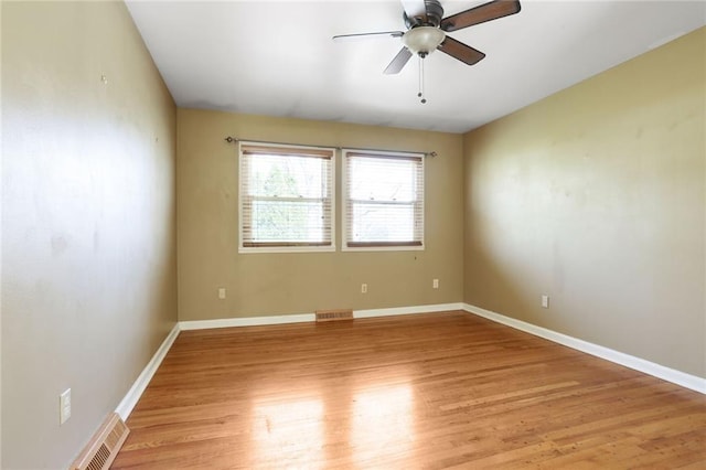 unfurnished room with light wood finished floors, visible vents, and baseboards