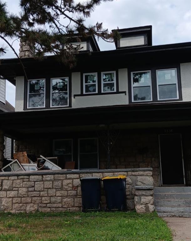 exterior space with stucco siding and stone siding