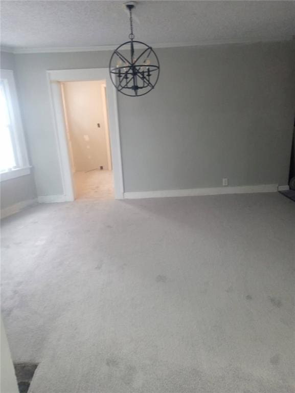 unfurnished room featuring carpet flooring, a textured ceiling, baseboards, and ornamental molding