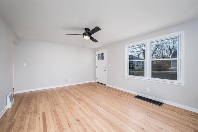 spare room featuring visible vents, light wood-type flooring, and baseboards