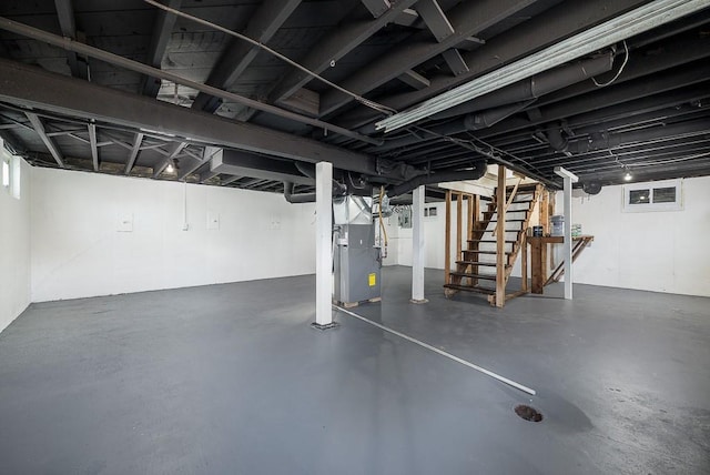 basement featuring stairs and heating unit