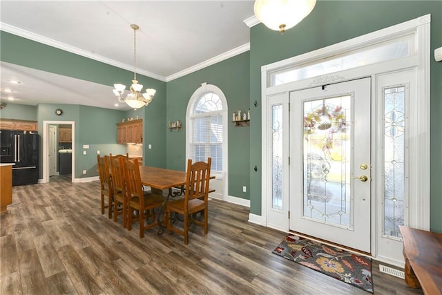 dining space featuring visible vents, crown molding, baseboards, a notable chandelier, and dark wood-style flooring