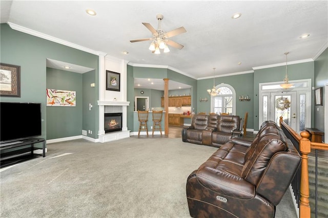 carpeted living area with crown molding, baseboards, recessed lighting, a fireplace, and a ceiling fan