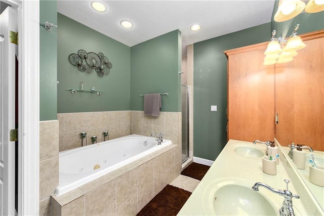 bathroom featuring a sink, a jetted tub, a shower stall, and double vanity