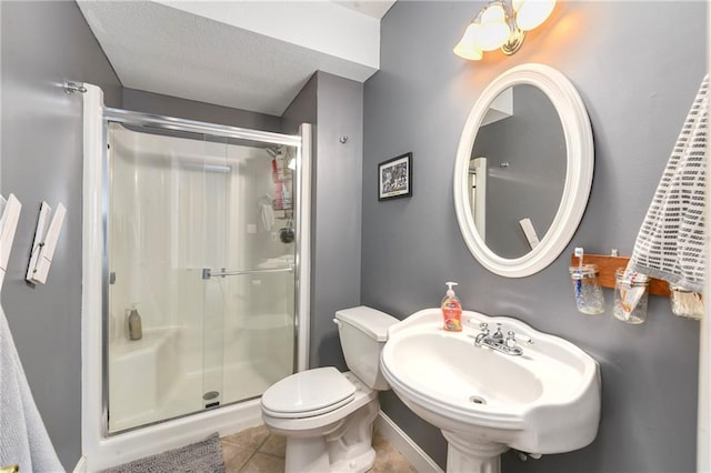 bathroom with tile patterned flooring, a shower stall, toilet, and a sink