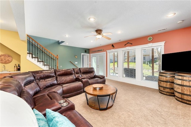 living room featuring a ceiling fan, carpet floors, recessed lighting, stairs, and a textured ceiling