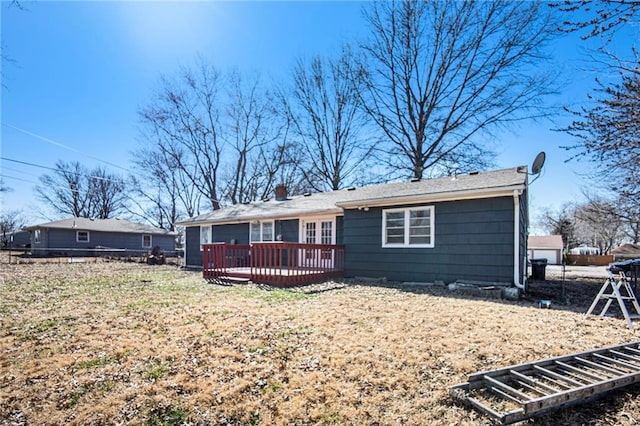 back of property with a wooden deck and fence