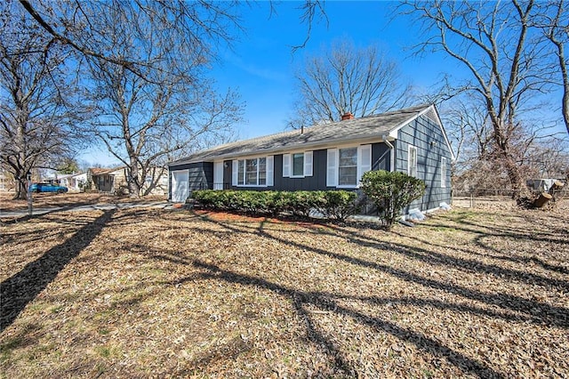 single story home featuring an attached garage, a chimney, driveway, and fence