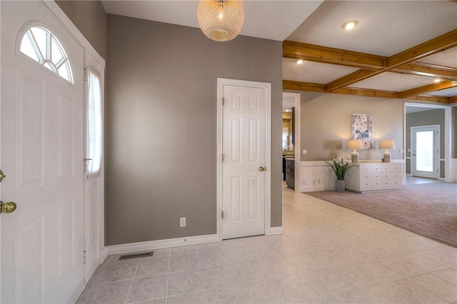 entryway with visible vents, beam ceiling, coffered ceiling, baseboards, and light colored carpet