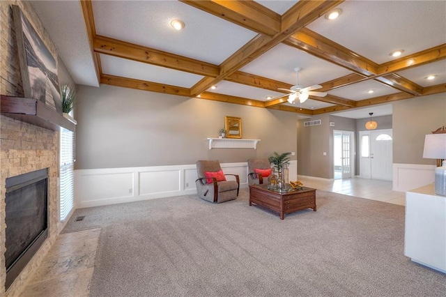 living area with visible vents, carpet floors, beamed ceiling, and a fireplace