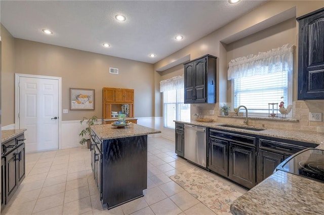 kitchen featuring visible vents, a center island, dishwasher, plenty of natural light, and a sink