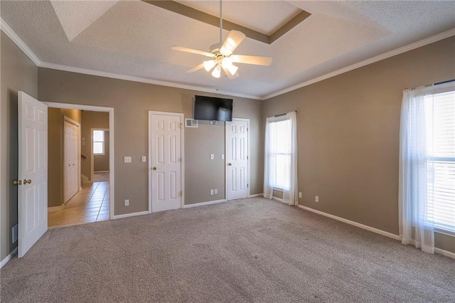 unfurnished bedroom featuring multiple windows, carpet floors, a textured ceiling, and crown molding