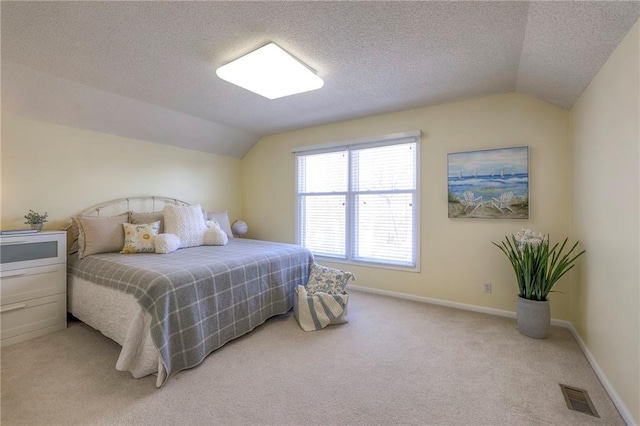 bedroom with baseboards, visible vents, lofted ceiling, a textured ceiling, and light carpet