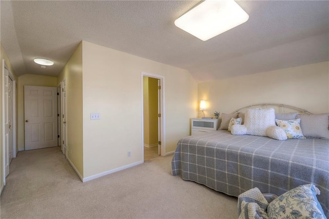 bedroom featuring vaulted ceiling, carpet, baseboards, and a textured ceiling