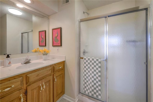 full bath featuring visible vents, a stall shower, and vanity