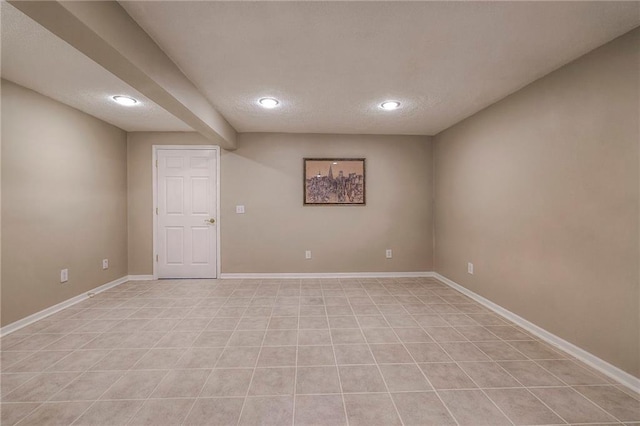 spare room with recessed lighting, baseboards, and a textured ceiling