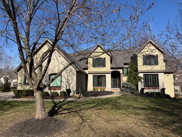 french provincial home with a front yard