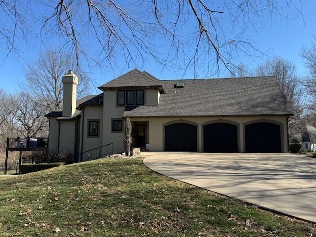 view of front of house with concrete driveway, a front yard, stucco siding, a chimney, and a garage