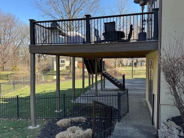 view of home's community featuring stairway, a lawn, a deck, and fence