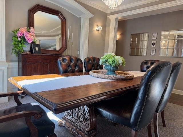 dining room with ornate columns, a chandelier, and ornamental molding