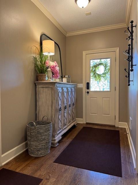 doorway with a textured ceiling, wood finished floors, baseboards, and ornamental molding