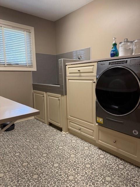 washroom with washer / dryer and cabinet space