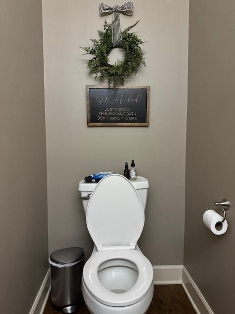 bathroom featuring toilet, wood finished floors, and baseboards