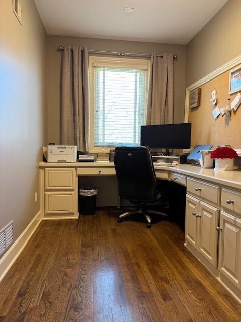 office space with dark wood finished floors, visible vents, and baseboards