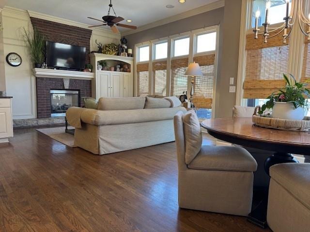 living room with dark wood finished floors, a brick fireplace, and ornamental molding